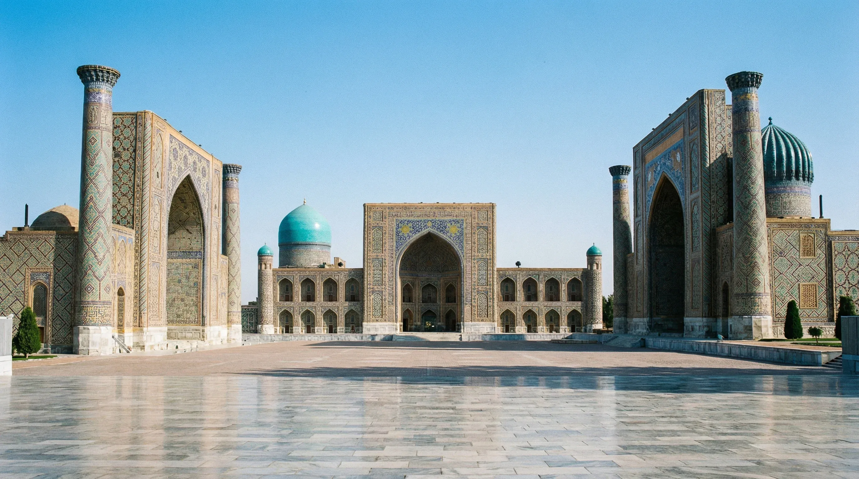 The three massive madrasahs with blue tile mosaics surrounding Registan Square in Samarkand.