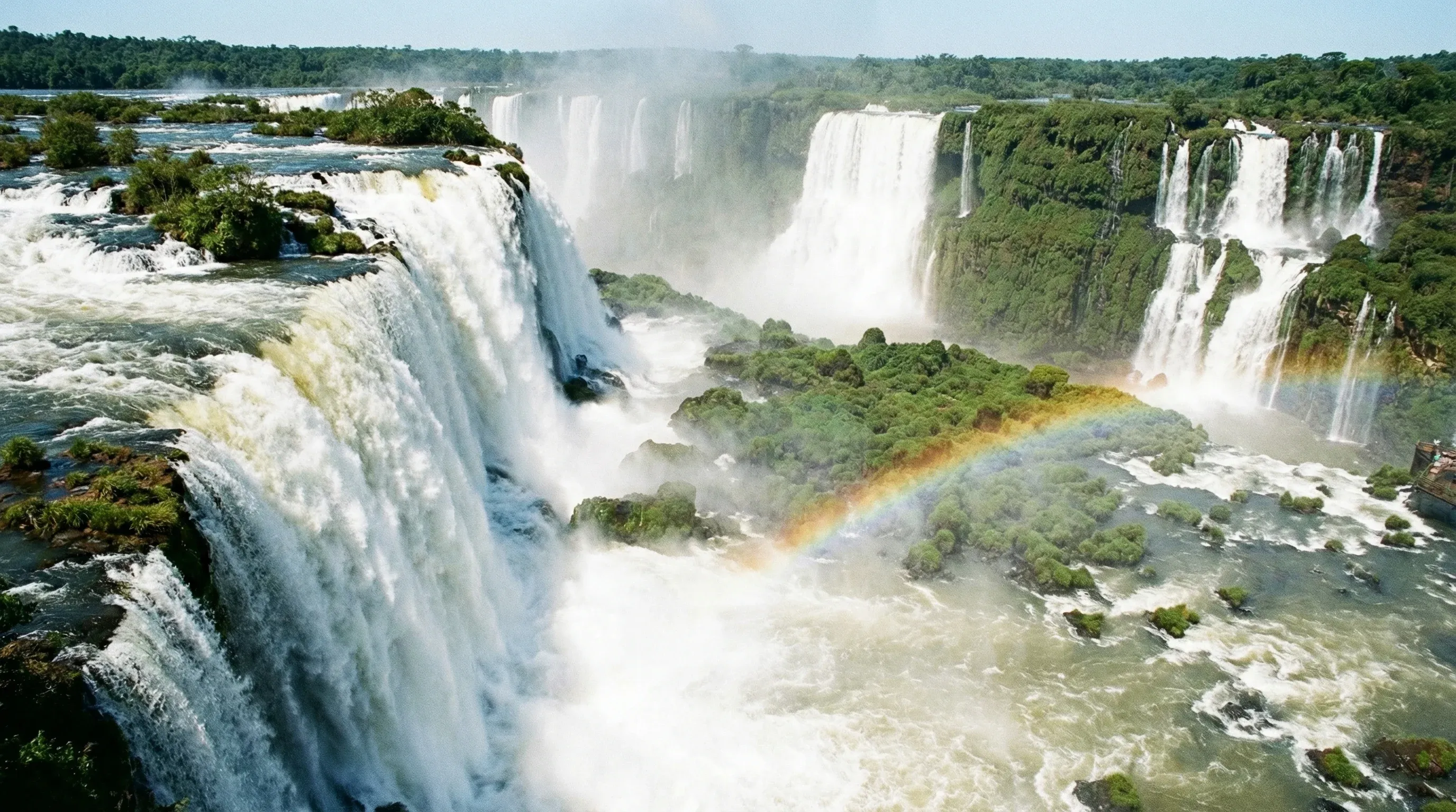 A wide view of the massive Garganta del Diablo waterfall at Iguazú National Park surrounded by green jungle.