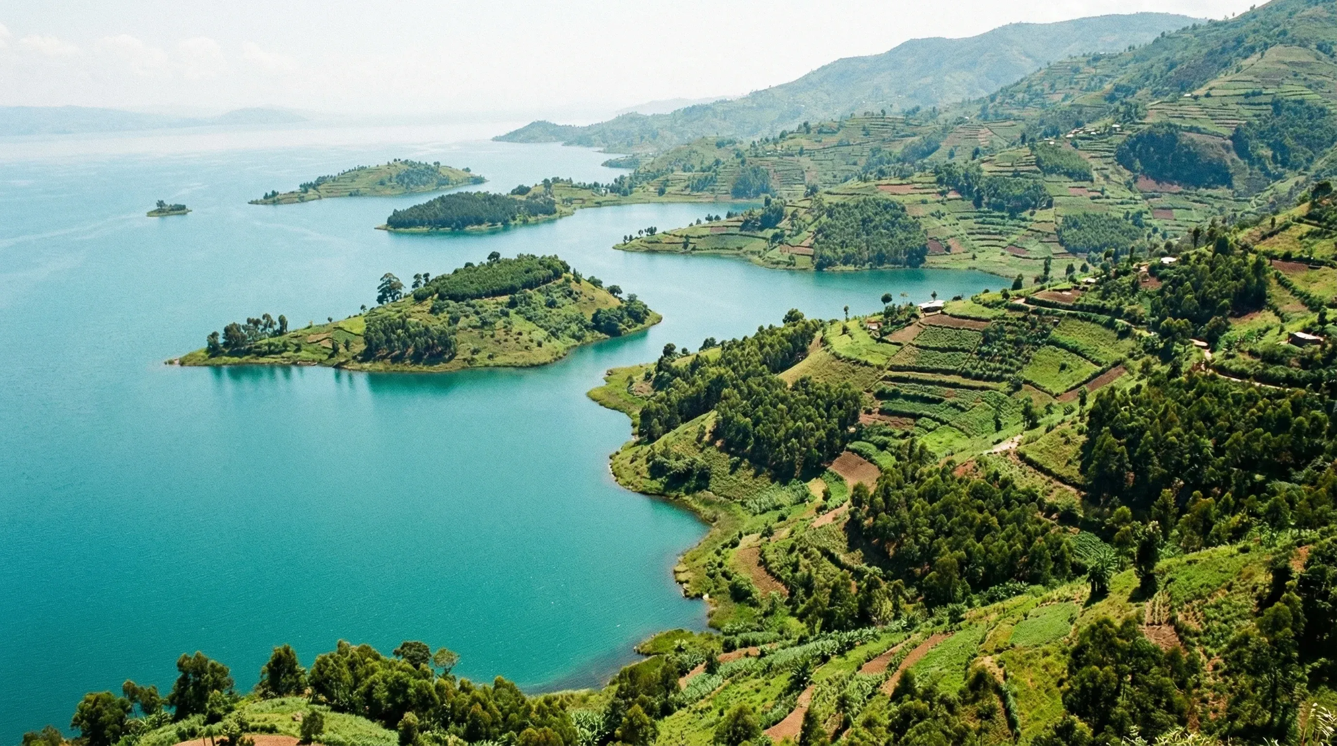 A wide view of the islands in Lake Kivu near Karongi, featuring green hills and bright blue water under a clear sky.