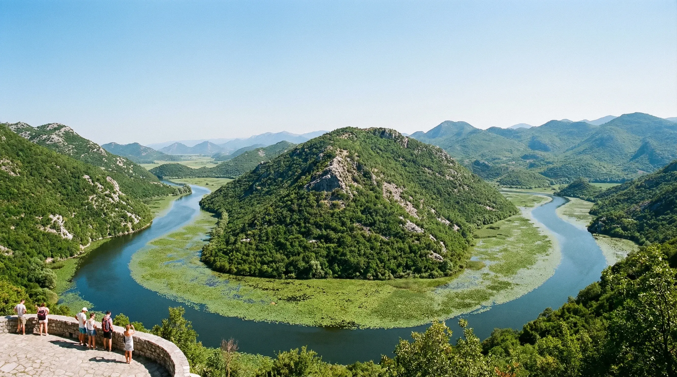 A high-angle view of a river winding in a horseshoe curve around a green hill in Lake Skadar National Park.