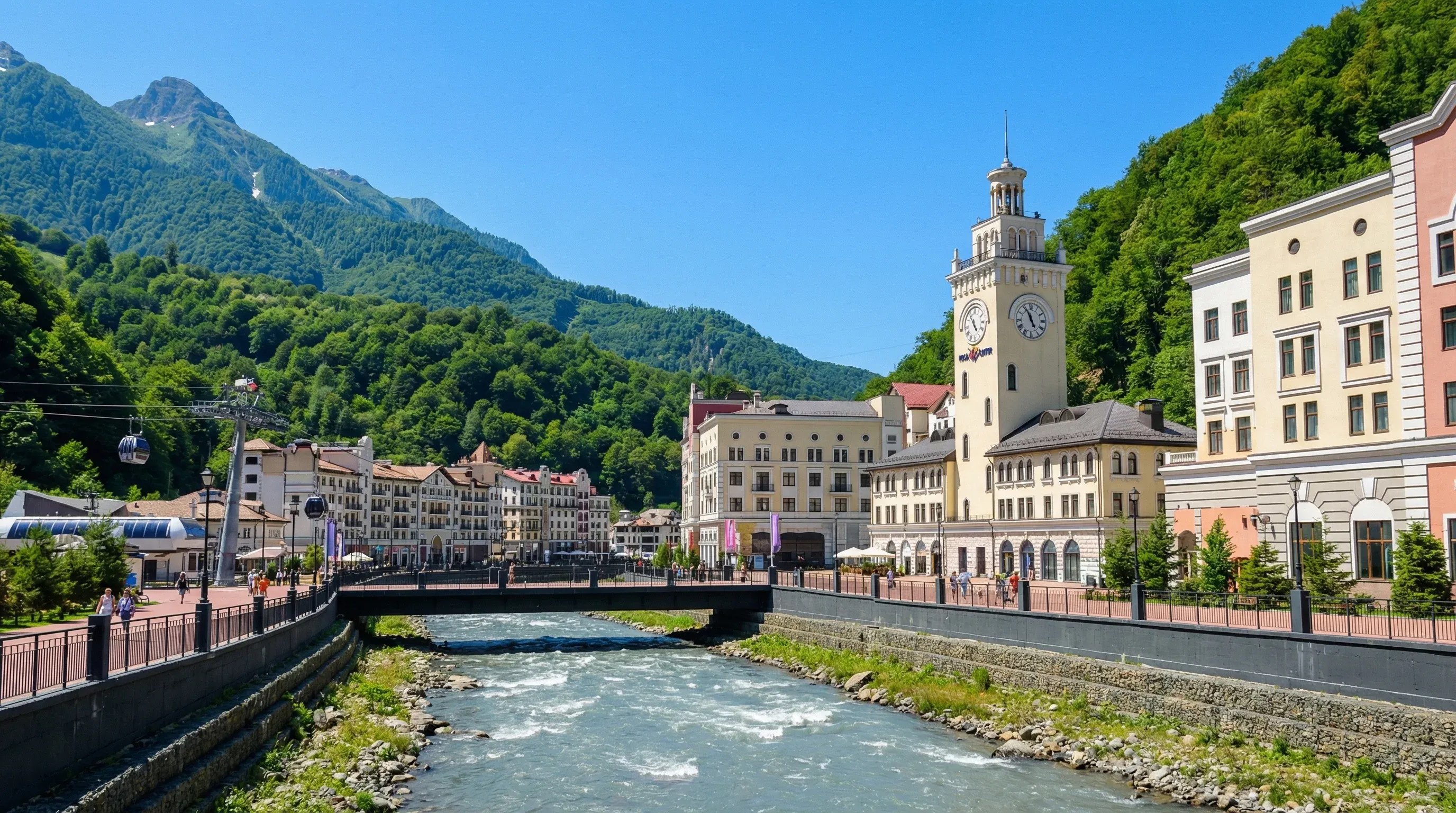 The Rosa Khutor resort buildings and clock tower along the Mzymta River, with the Caucasus Mountains in the background.