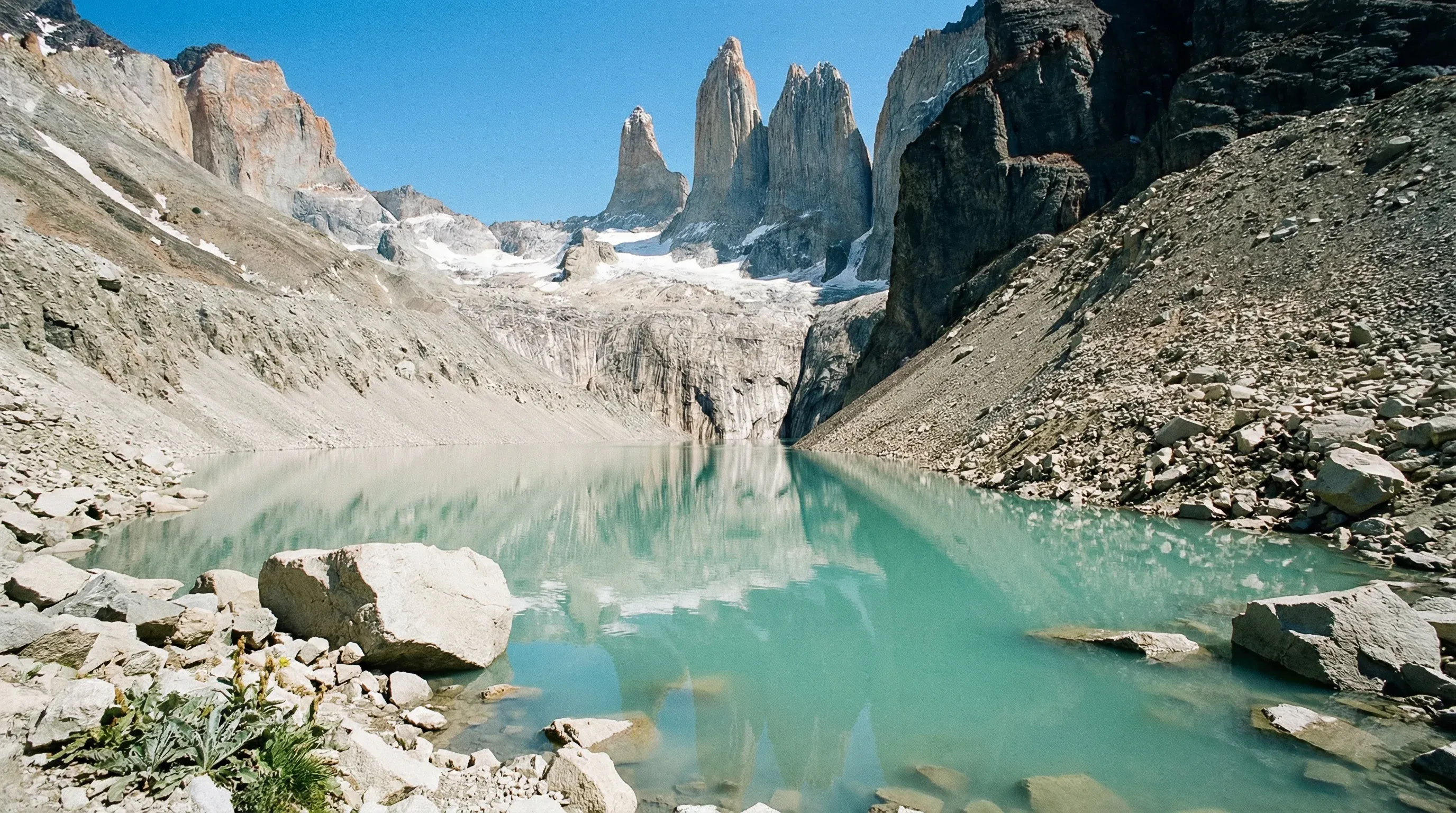 The three granite towers of Torres del Paine reflecting in a turquoise glacial lake in Southern Patagonia.
