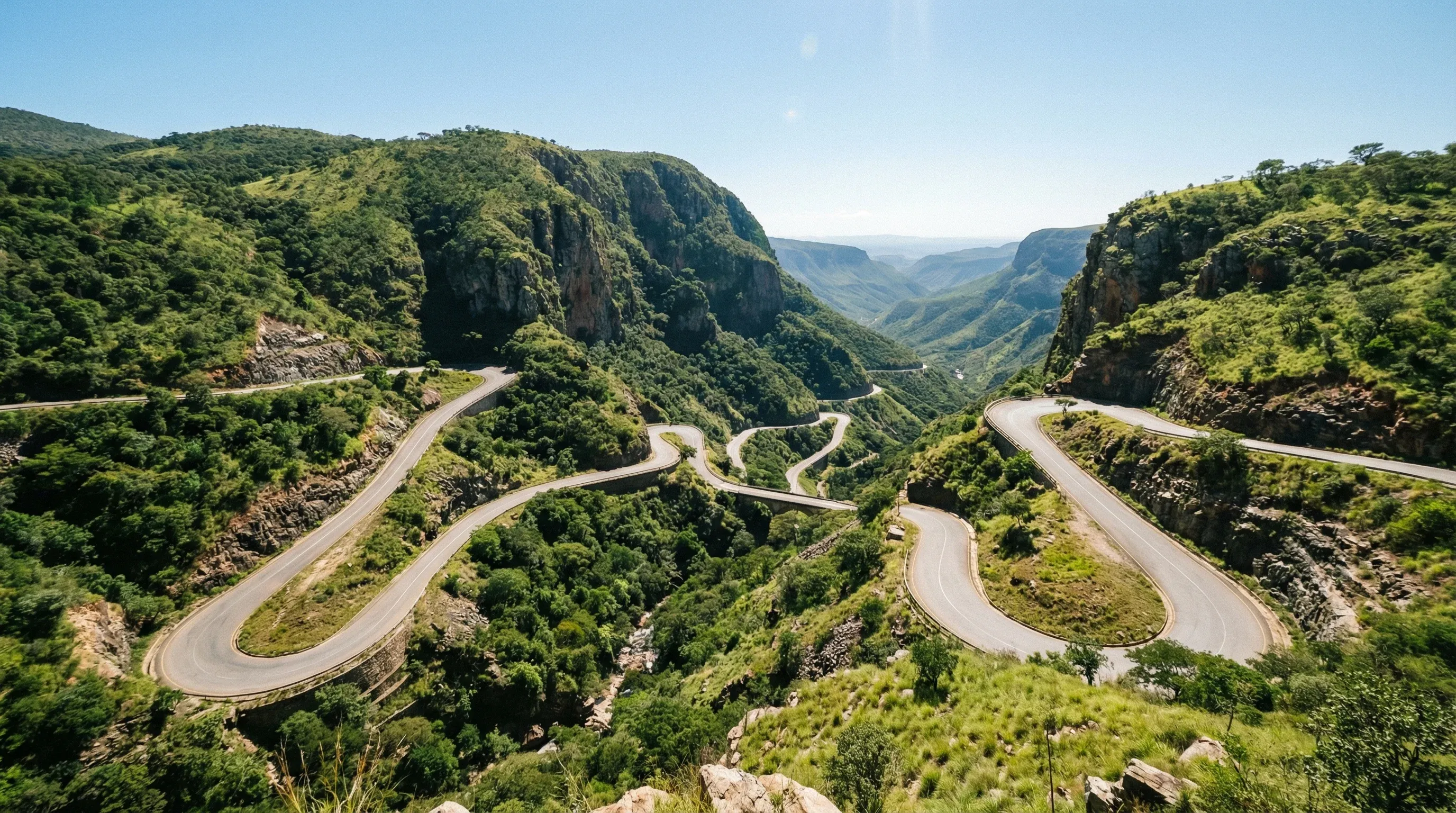 The winding hairpin turns of the Serra da Leba mountain pass descending a steep green escarpment in Huíla, Angola.